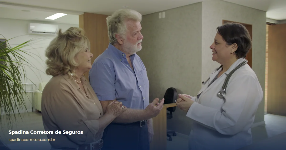 Casal de idosos conversando com uma médica em um corredor de clínica